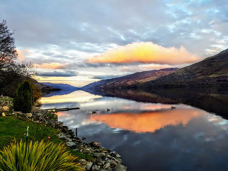 Romantic scene, tangerine clouds over Loch Earn from Briar Cottages
